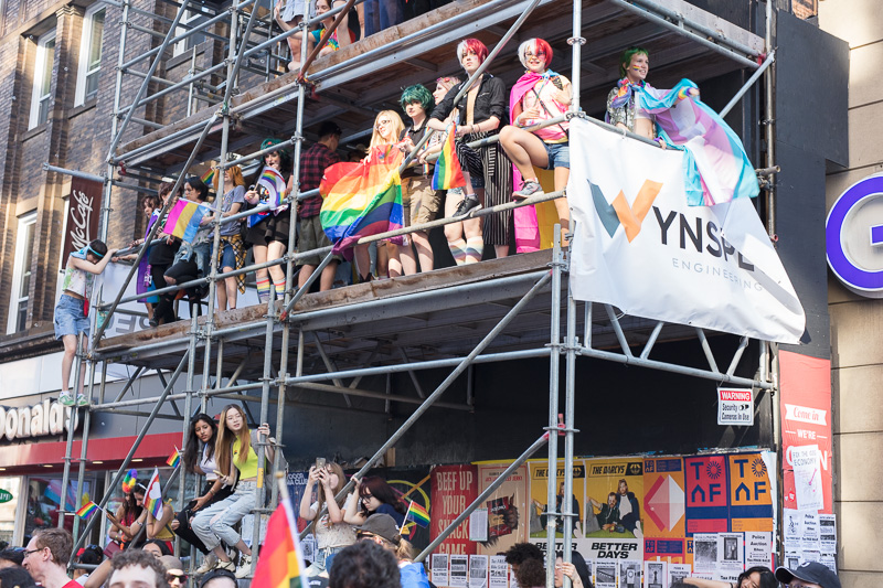 Pride partiers watching parade from scaffolding