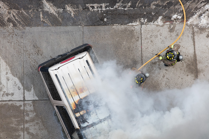Firemen dousing burning van