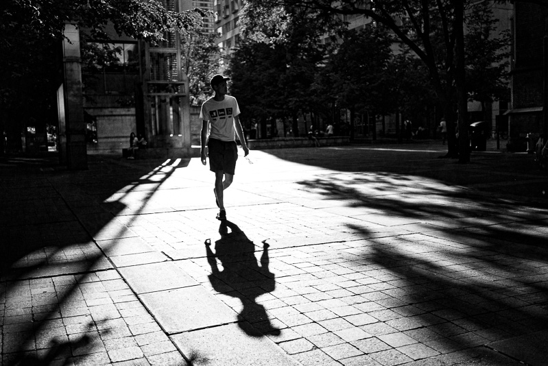 Man walking in sunlight and casting long shadow