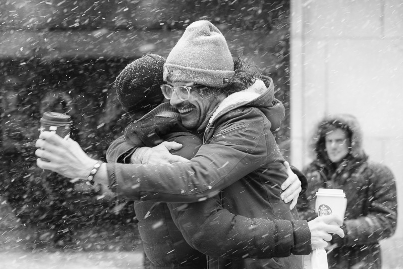 Friends share a hug during a snow storm