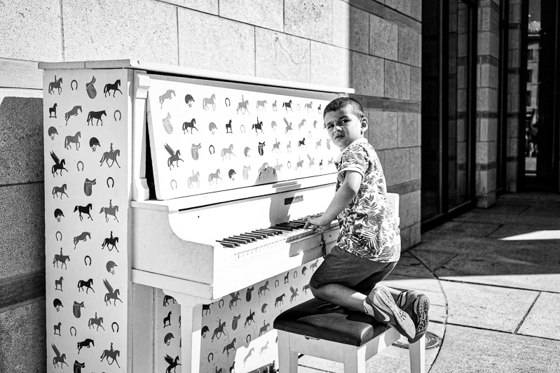 Boy plays piano outside Montreal Museum of Archaeology and History