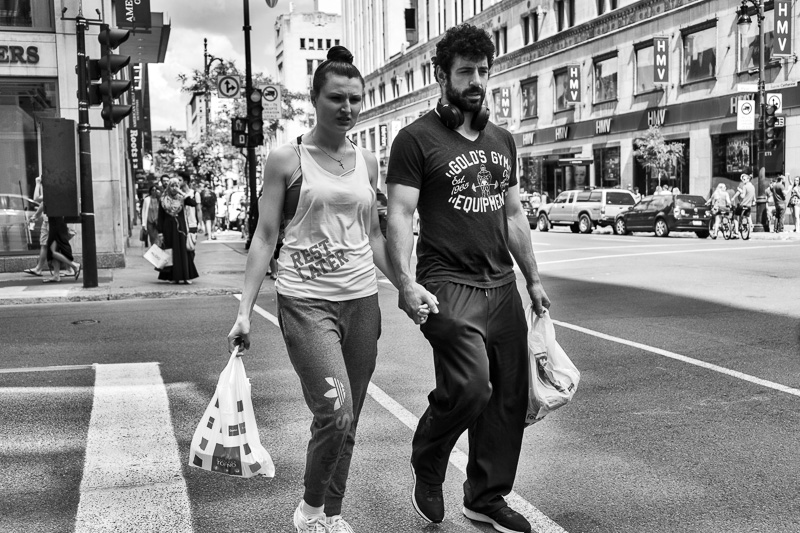 Couple holding hands, crossing street (Sainte-Catherine & Peel), Montreal