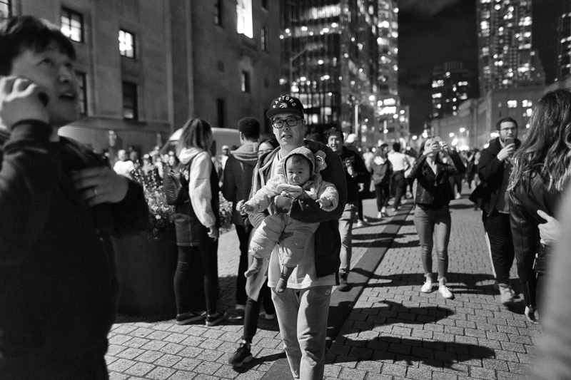 Raptor fan with baby on Front Street, Toronto