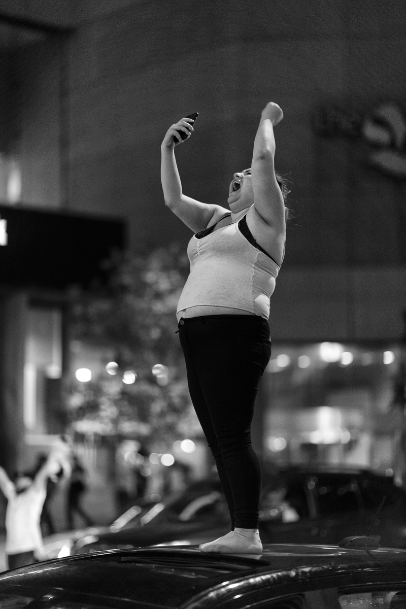 Woman standing on car and screaming, Bloor Street, Toronto