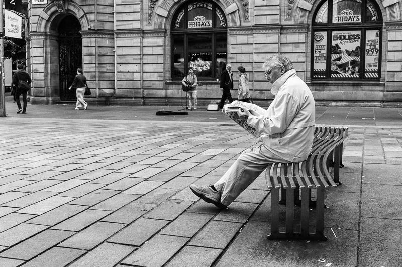 Reading Newspaper on Buchanan Street, Glasgow, Scotland