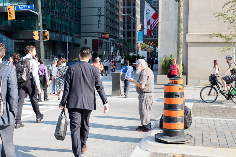 Panhandling as Toronto communters pass through the financial district during rush hour.