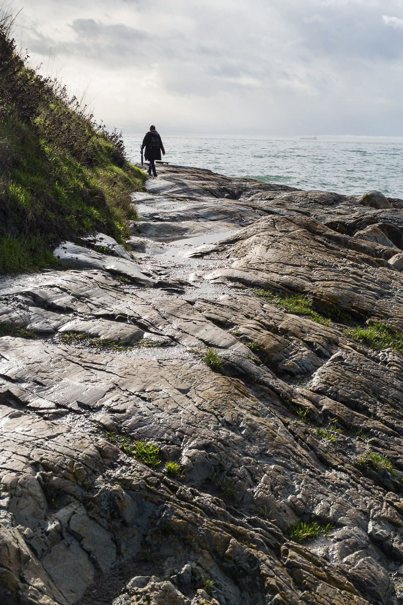 Walking along the rocky shore of James Bay, Victoria
