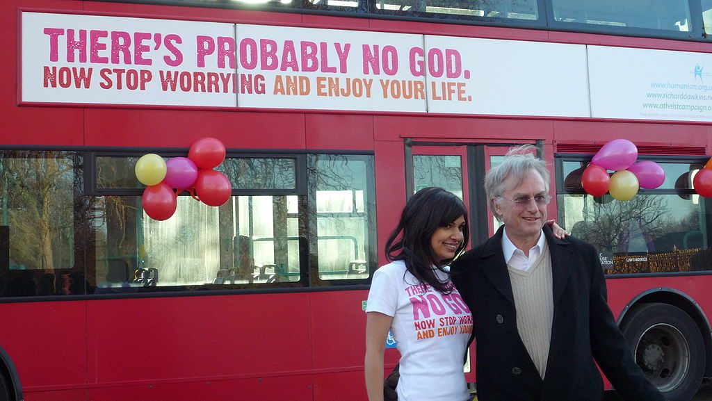 Ariane Sherine and Richard Dawkins posing in front of an atheist ad