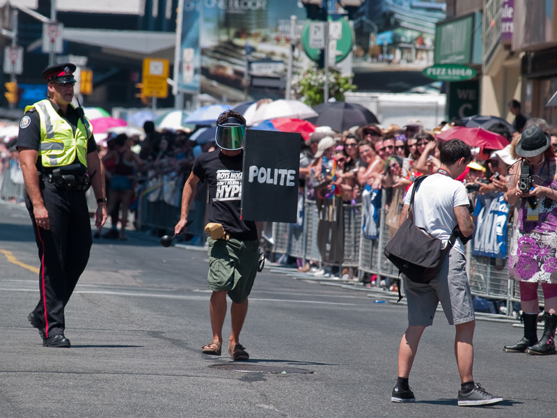 Police officer yells at person mocking G20 police.