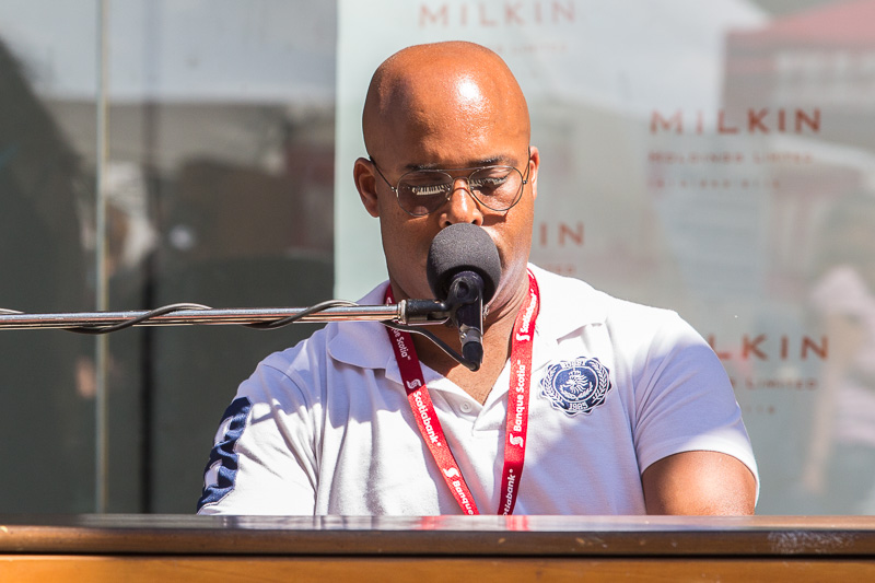 Man playing keyboard and singing into microphone