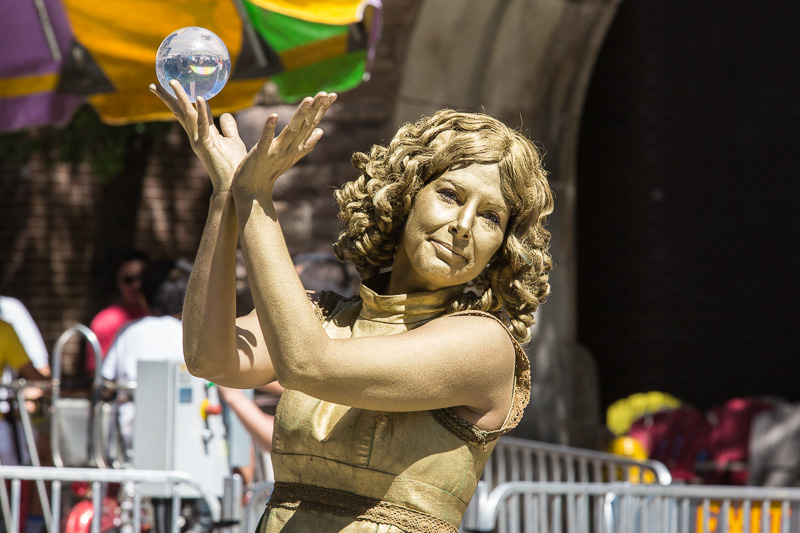 Woman in gold body paint holding crystal ball