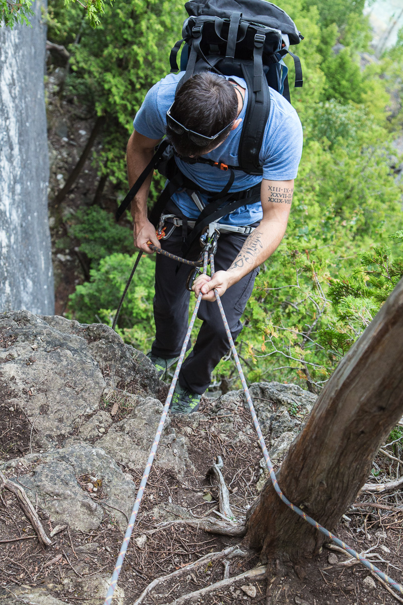 Rappelling down the face of a cliff