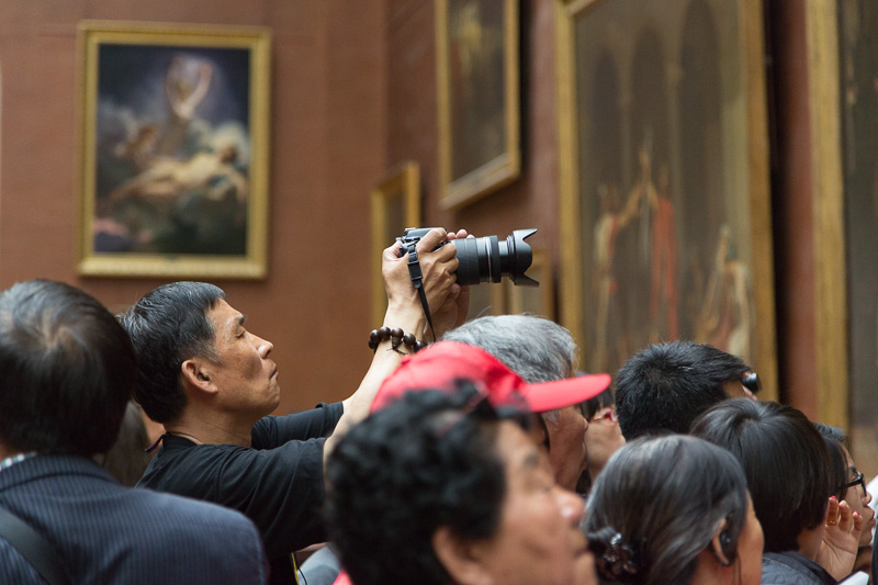 Tourist taking photo at the Musée du Louvre, Paris