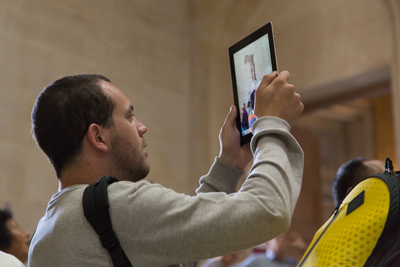 Tourist using iPad to take photos at the Musée du Louvre, Paris