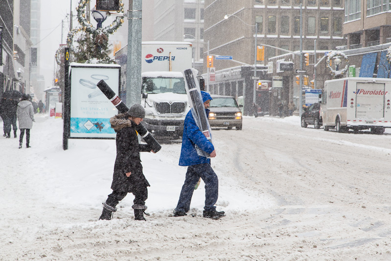 Carrying rugs across Bay Street @ Yorkville in snowstorm