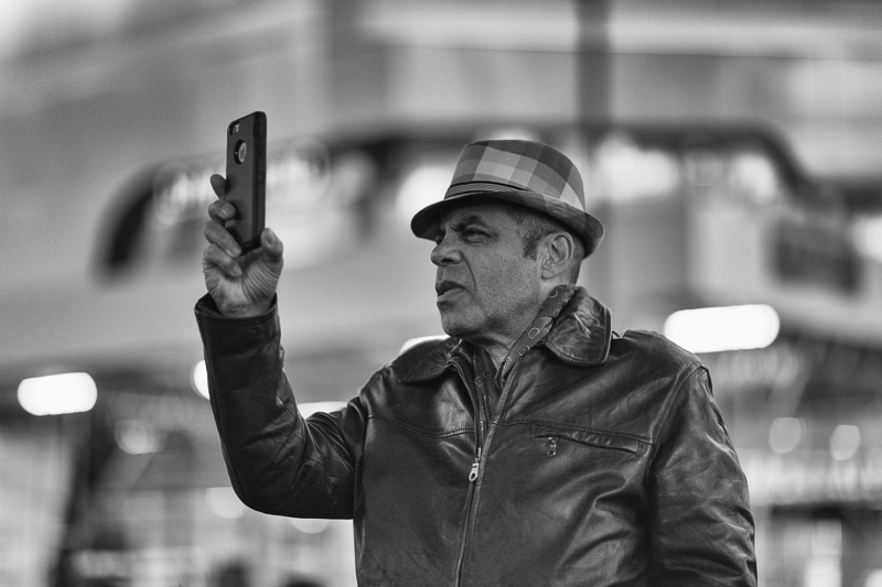 Man holding up a smart phone to take a photograph