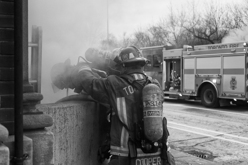 Two firefighters on the northwest corner of Sherbourne Street and Bloor Street East, Toronto