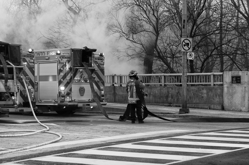 Toronto firefighter handling hose on Sherbourne Street bridge