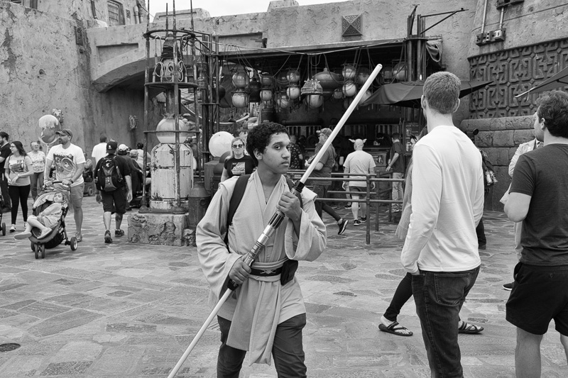 Park guest holding a light sabre at Star Wars: Galaxy's Edge in Disney's Hollywood Studios.