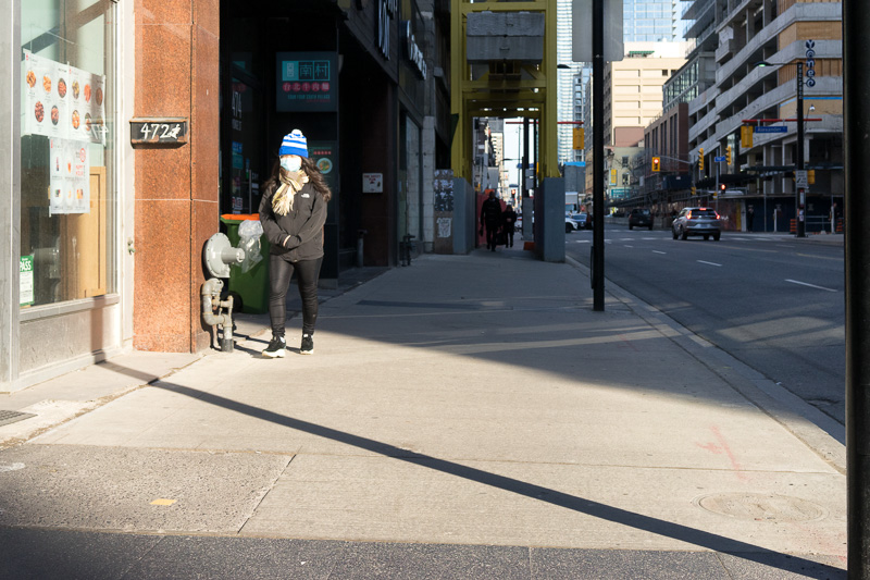 Woman wears face mask while walking down street