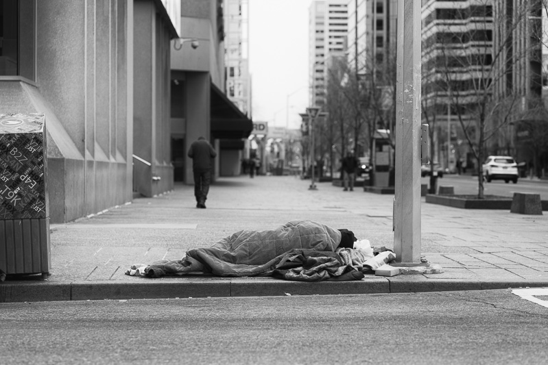 Homeless person lying on northeast corner of Yonge and Bloor Streets, Toronto