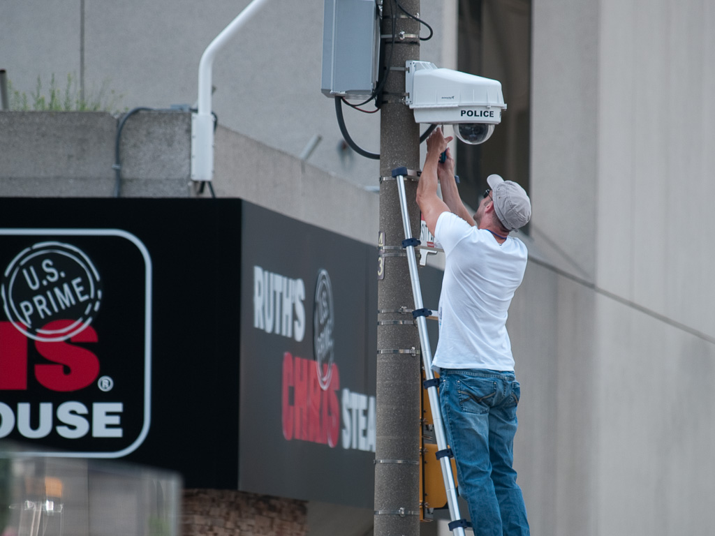 Man installs surveillance camera, G20 Summit, Toronto, June 25, 2010
