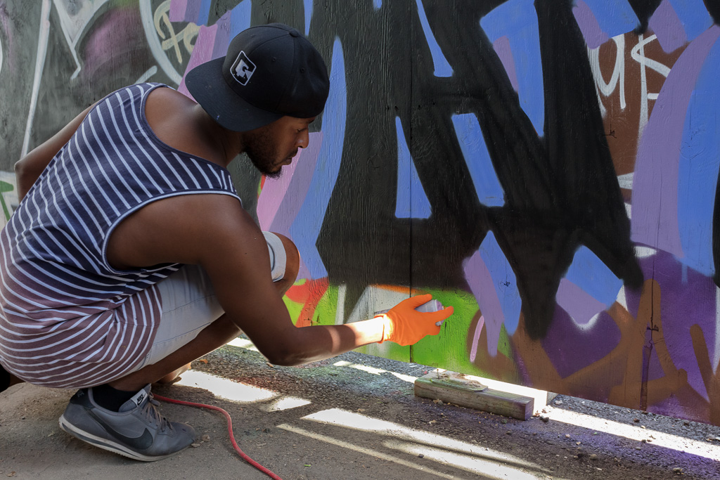 Spray painting a mural in Toronto's Graffiti Alley