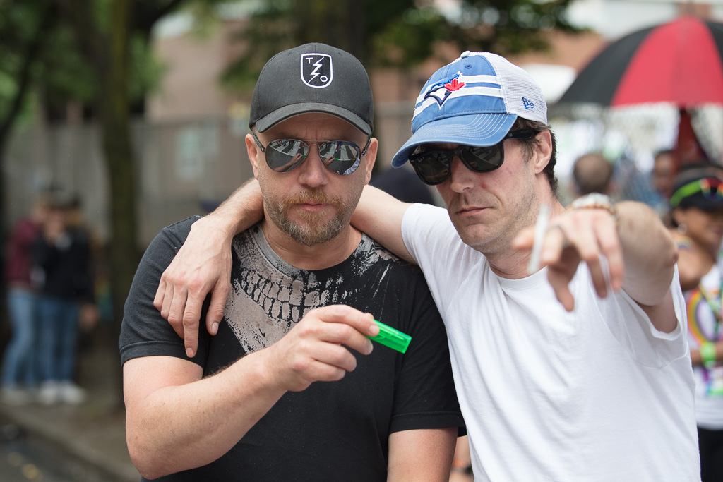 Sharing a green plastic cigarette lighter on Church Street, Toronto, 2018