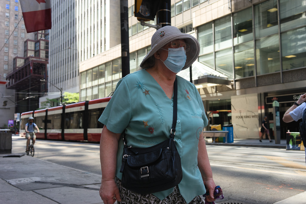 Woman wears a mask on King Street, Toronto