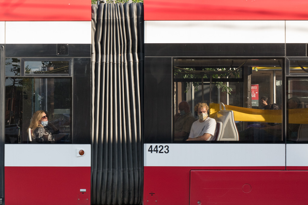 People wearing masks ride on a Toronto streetcar