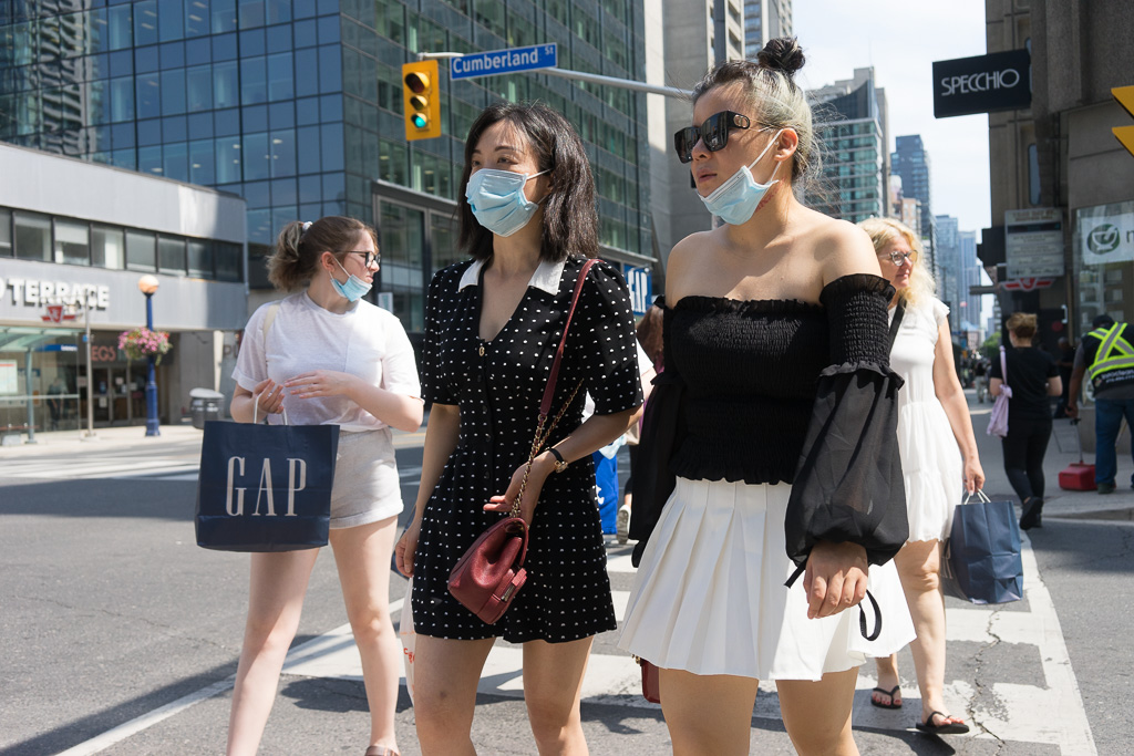 Girls cross street while wearing face masks