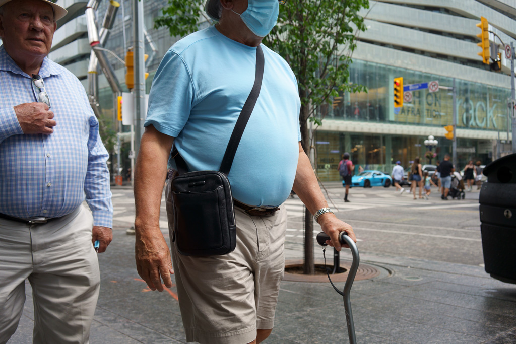 Man with cane at the Bloor/Yonge intersection in Toronto.