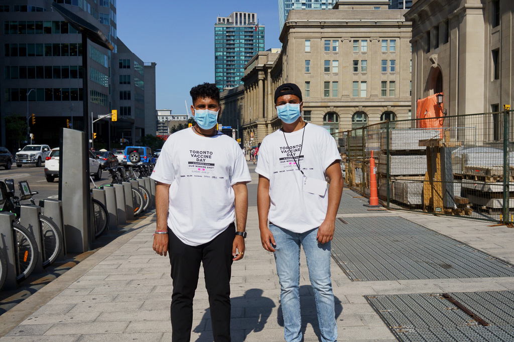 Two volunteers for Toronto Vaccine Day posing on Front Street.